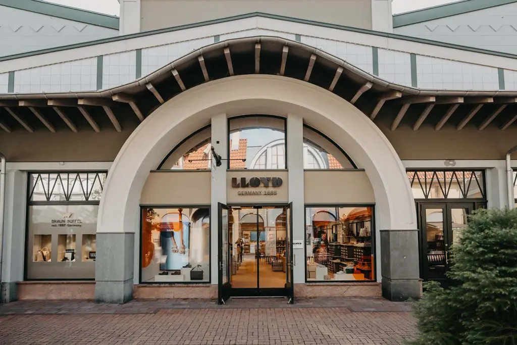 Ein LLOYD-Store von außen mit einem großen Säulenbogen über dem Eingang