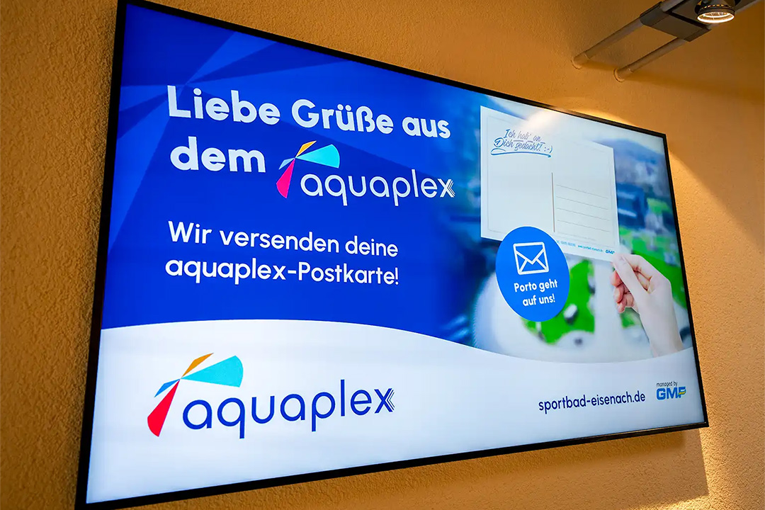 Ein Bildschirm zeigt eine Werbegrafik für die aquaplex Postkarte